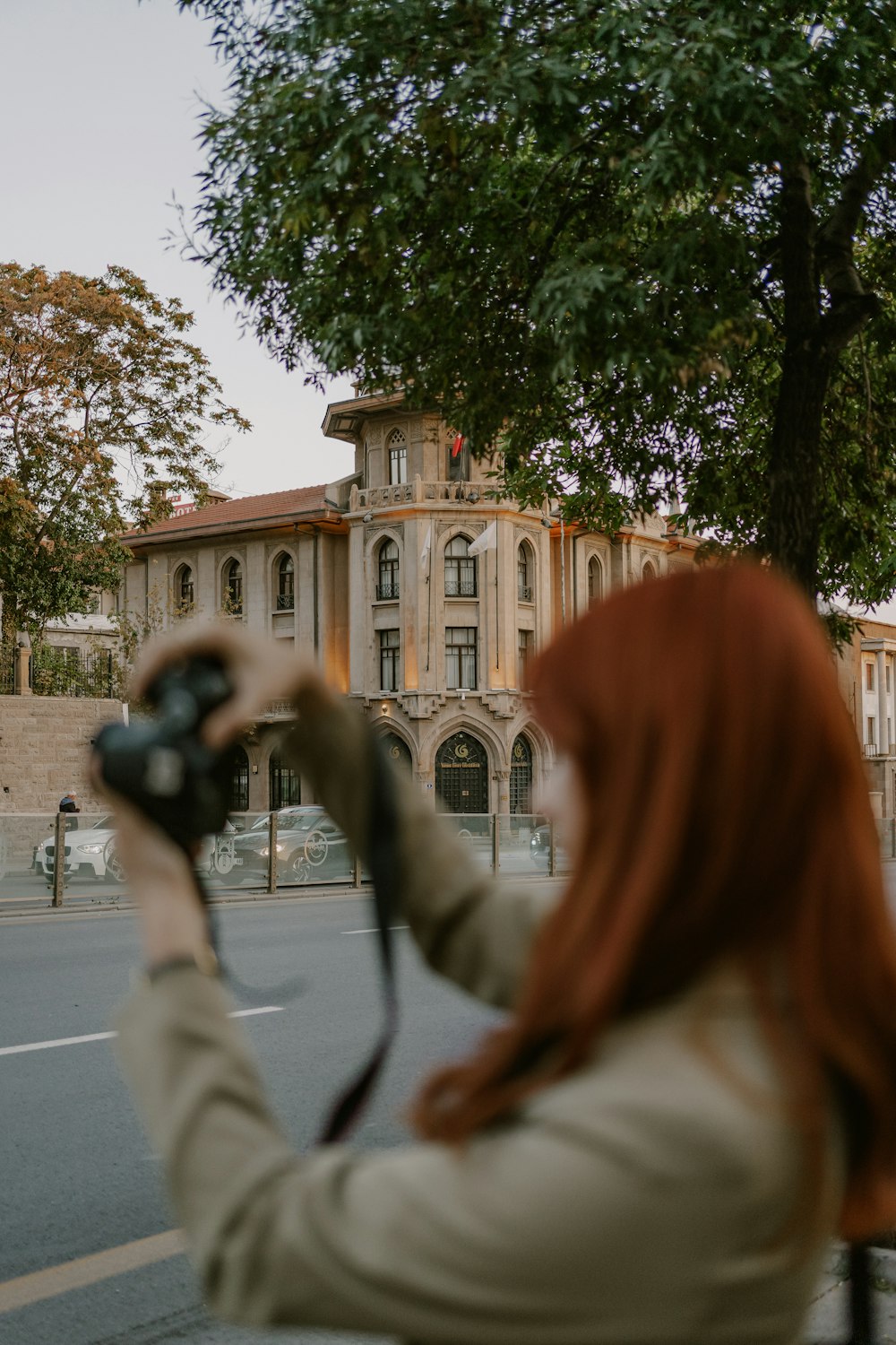 a woman taking a picture of a building with a camera