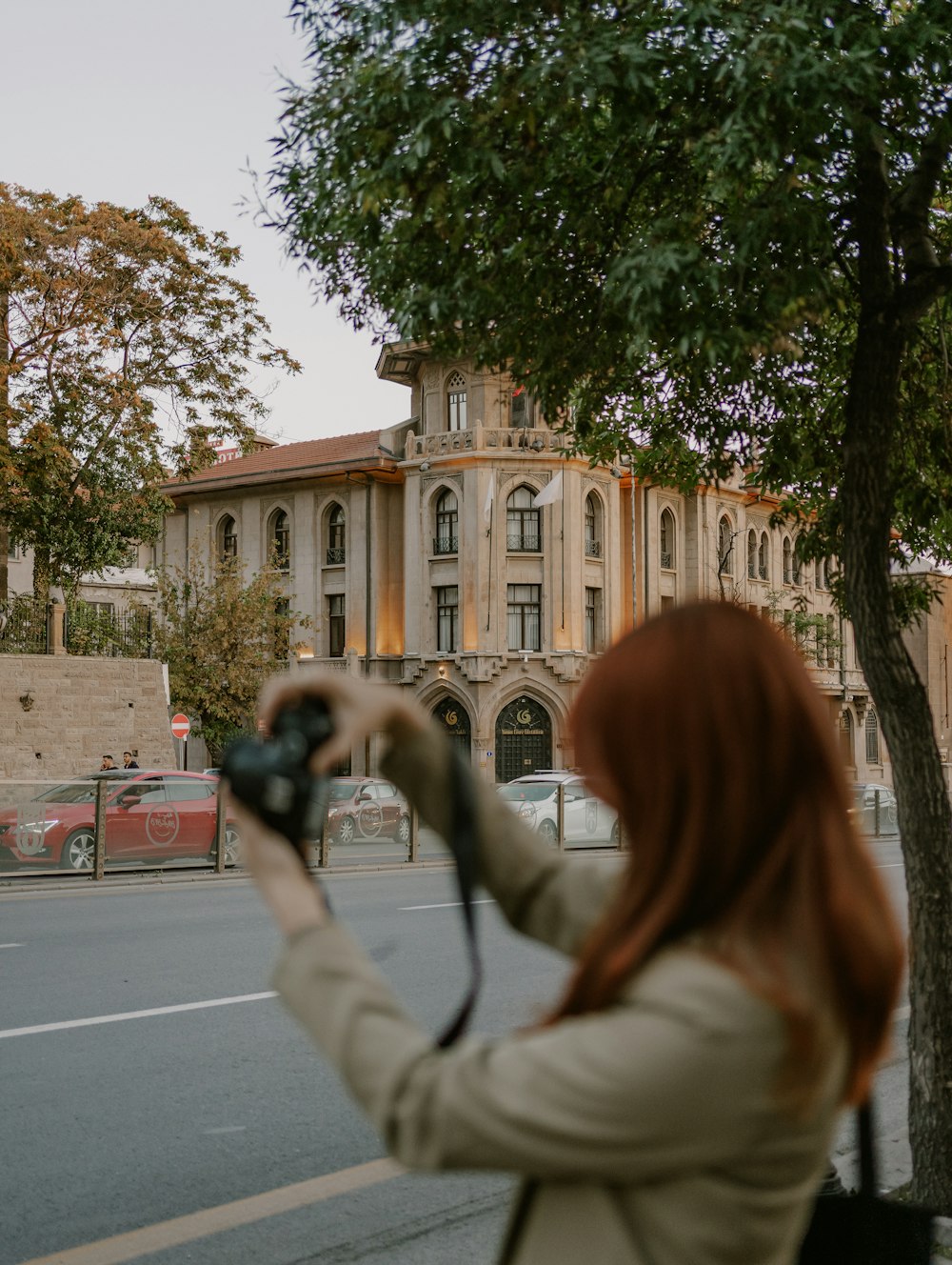 a woman taking a picture of a large building