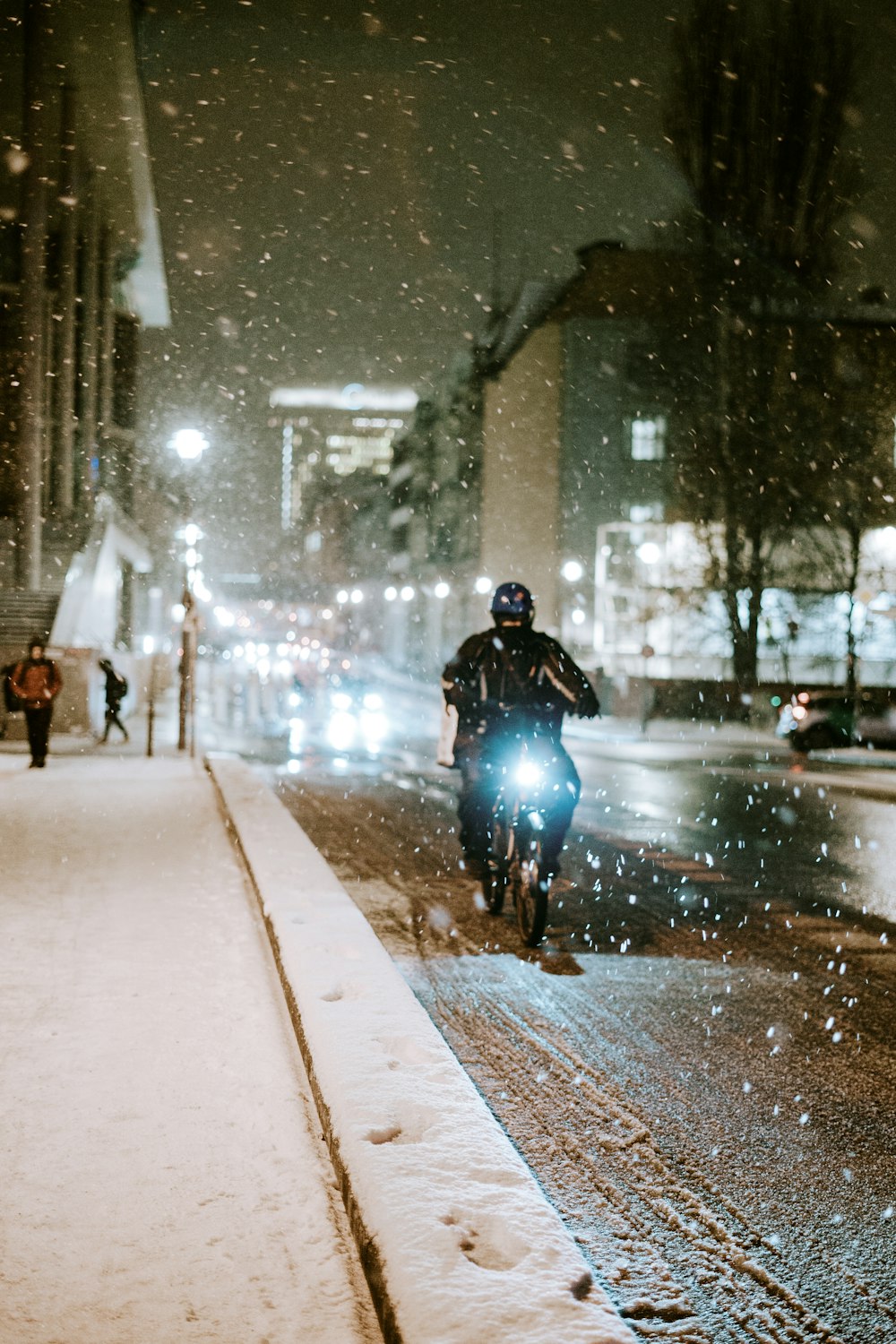 a man riding a bike down a snow covered street