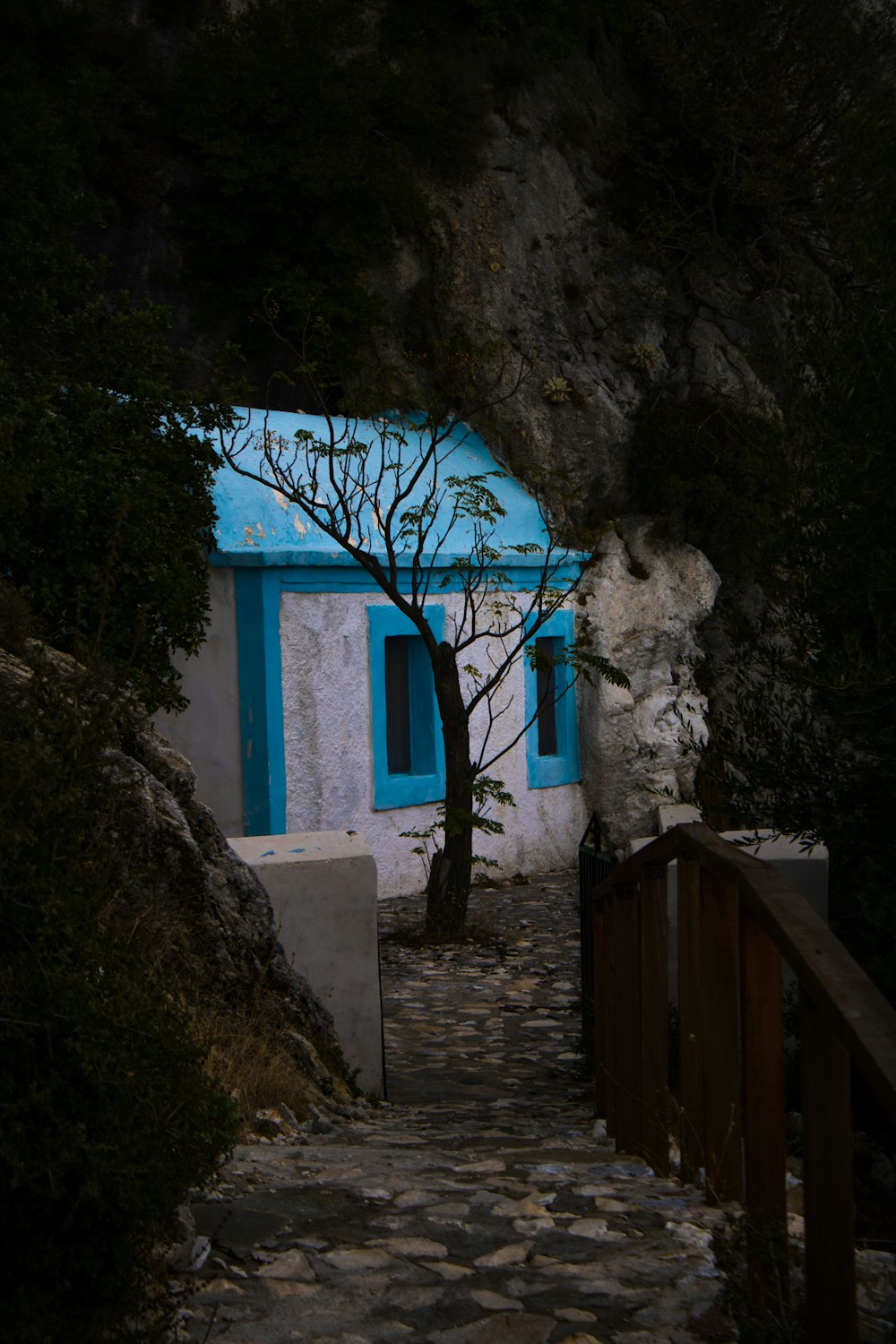 a stone path leading up to a blue building