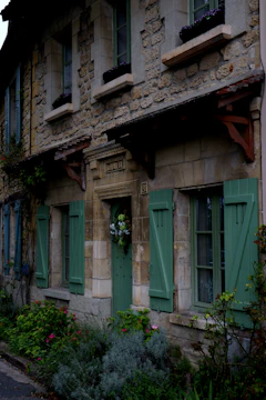 Exterior view of a renovated traditional Saint-Malo stone house with fresh paint and new windows