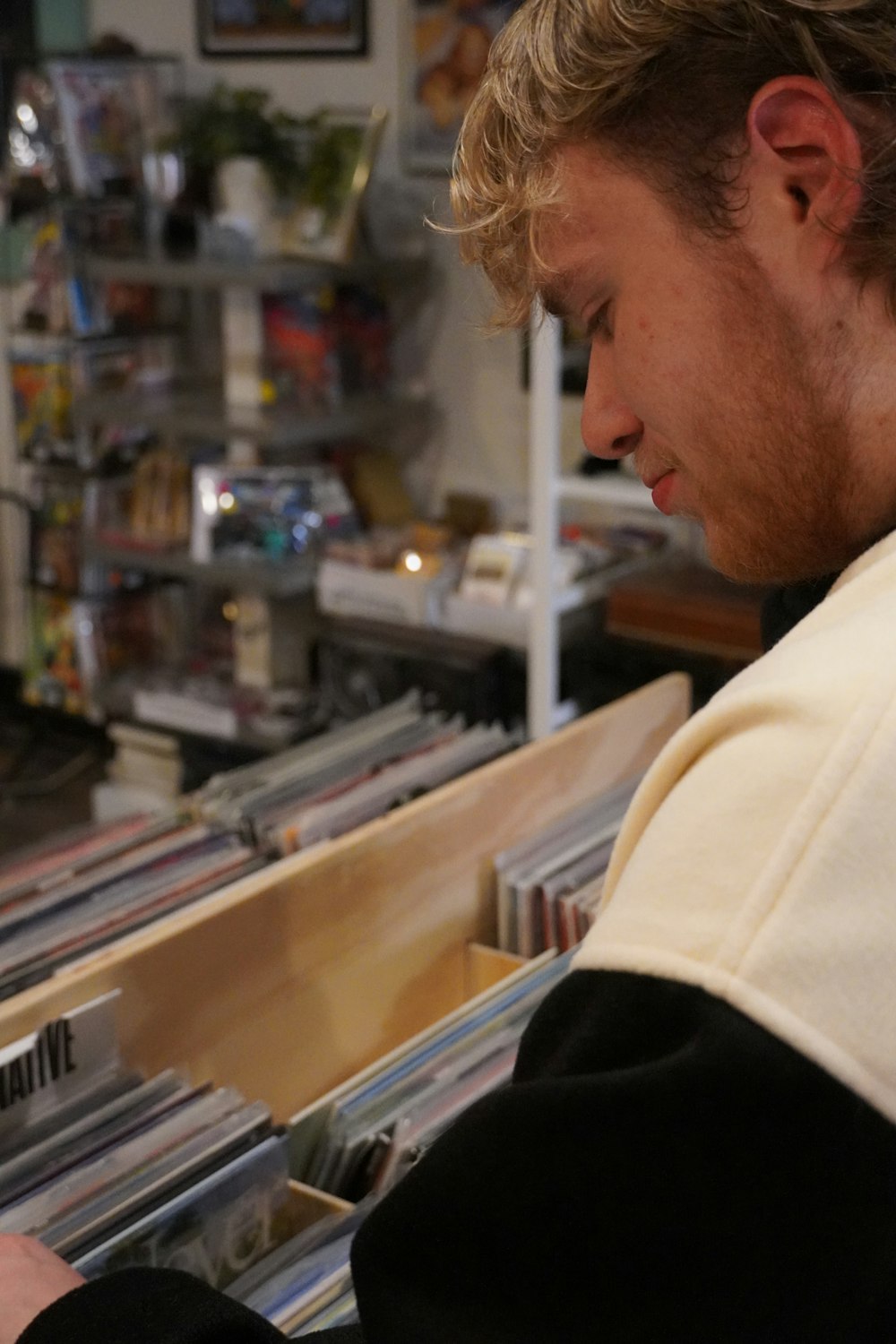 a man looking at a cd in a record store