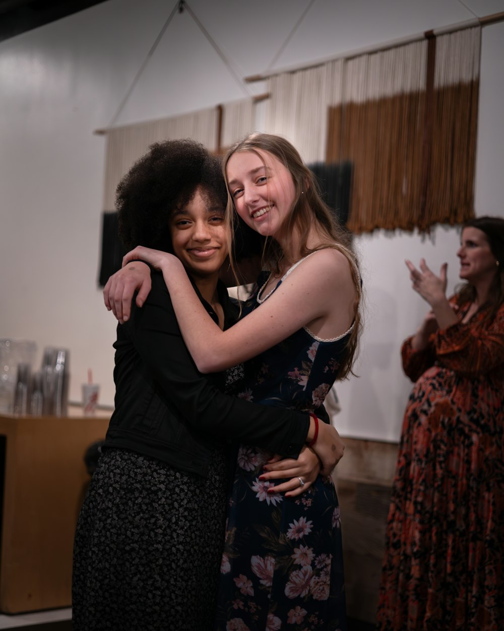 two women hugging each other in a room