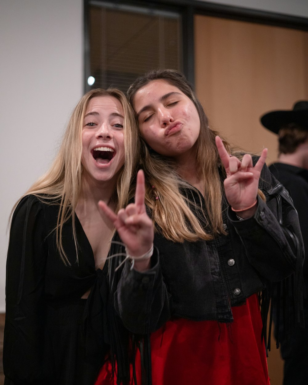 two young women making a peace sign with their hands
