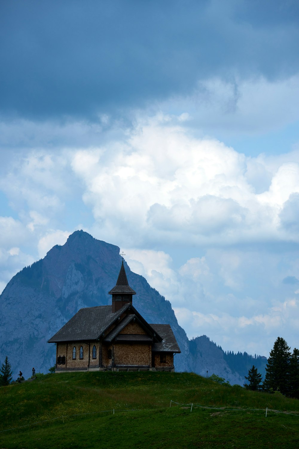 a church on a hill with a mountain in the background