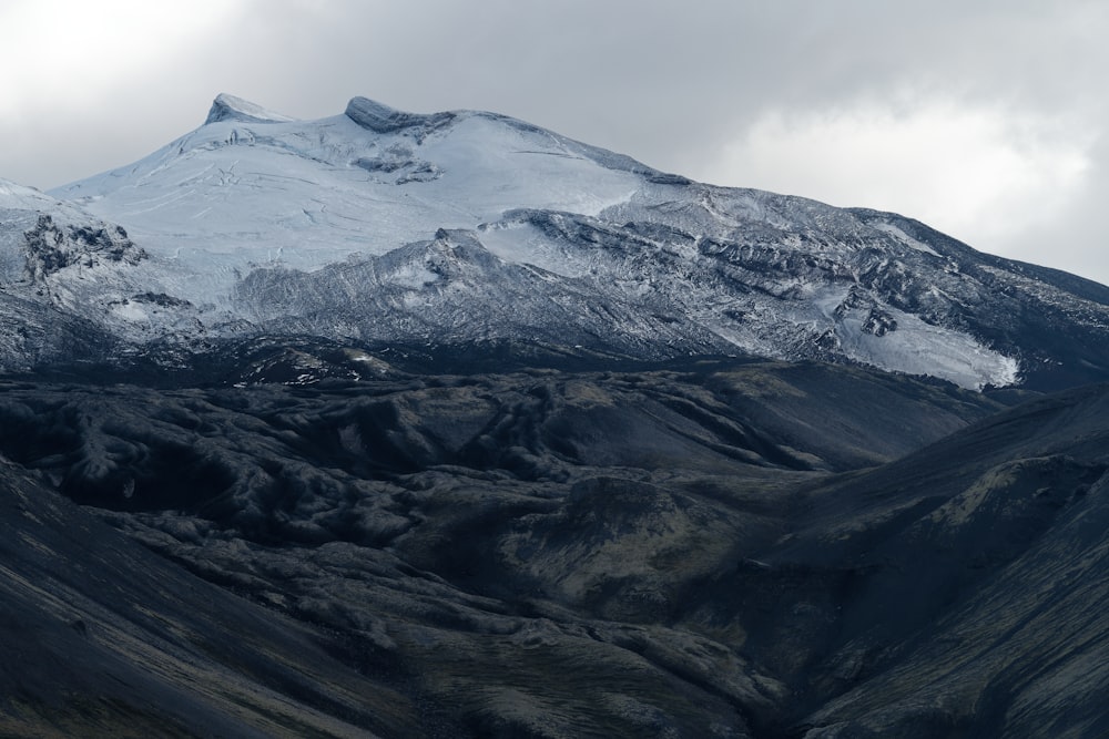 a mountain covered in snow with a sky background