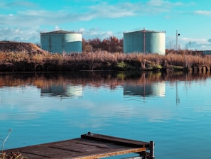 Fuel tanks lined up at a refinery under a clear sky.