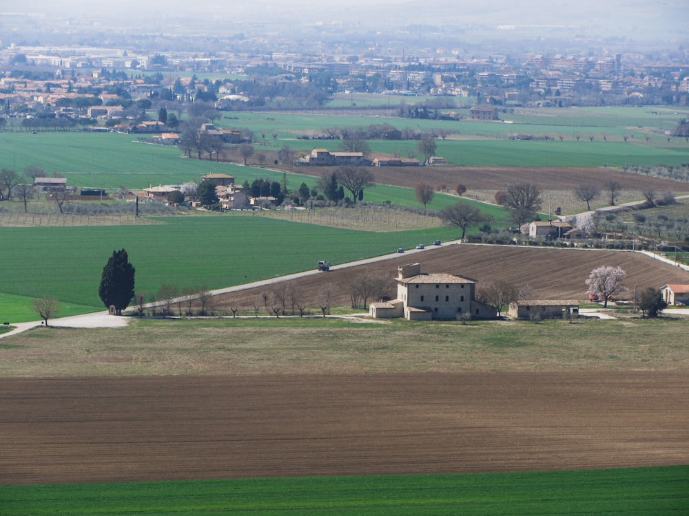 an aerial view of a farm with a house in the foreground