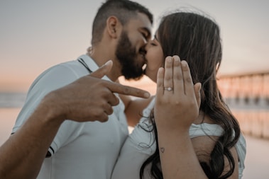 a man and a woman kissing on the beach