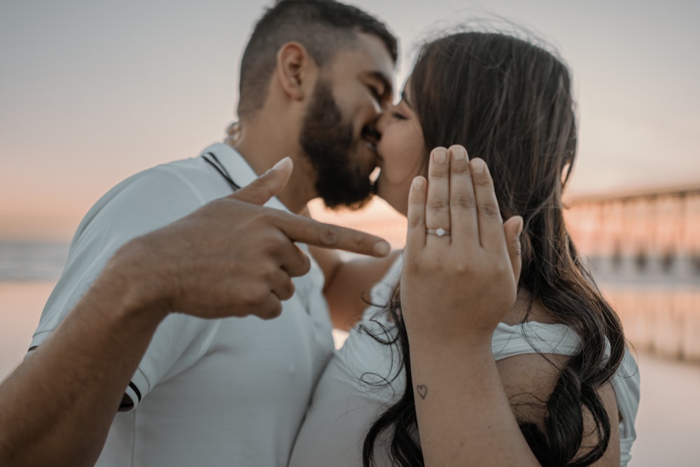 a man and a woman kissing on the beach