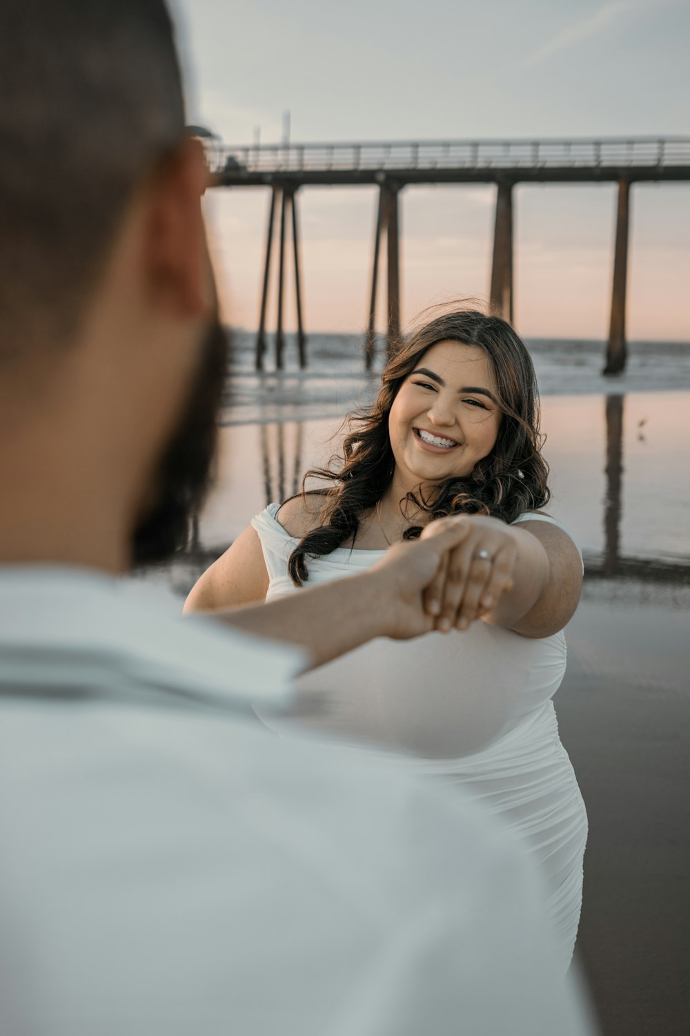 a woman in a white dress pointing a gun at a man in a white shirt