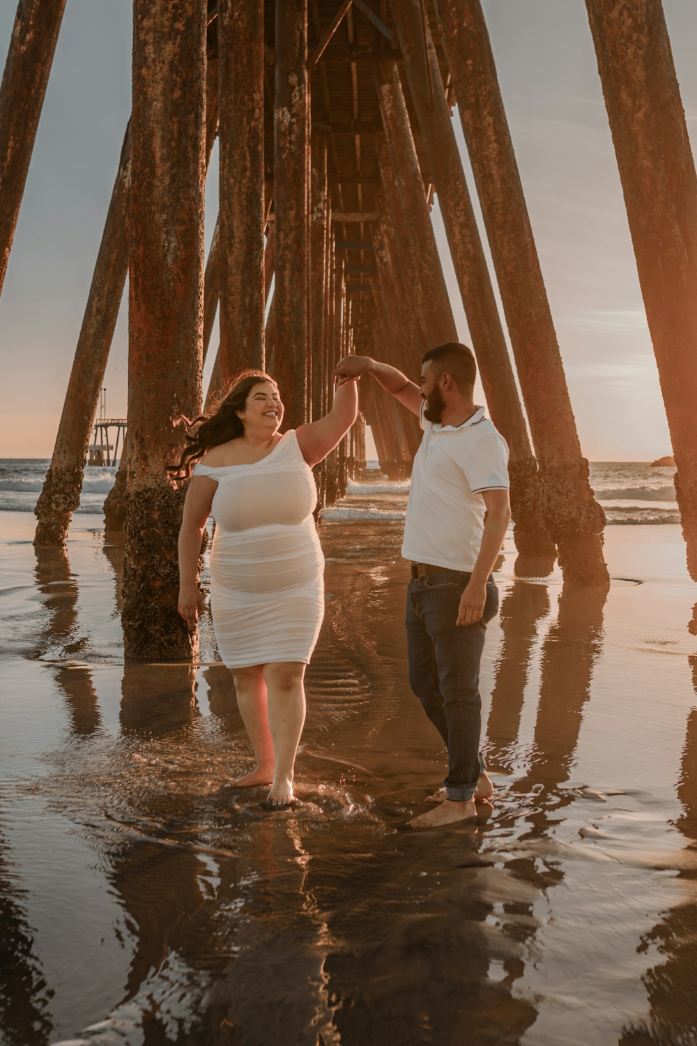 a man and a woman standing under a pier