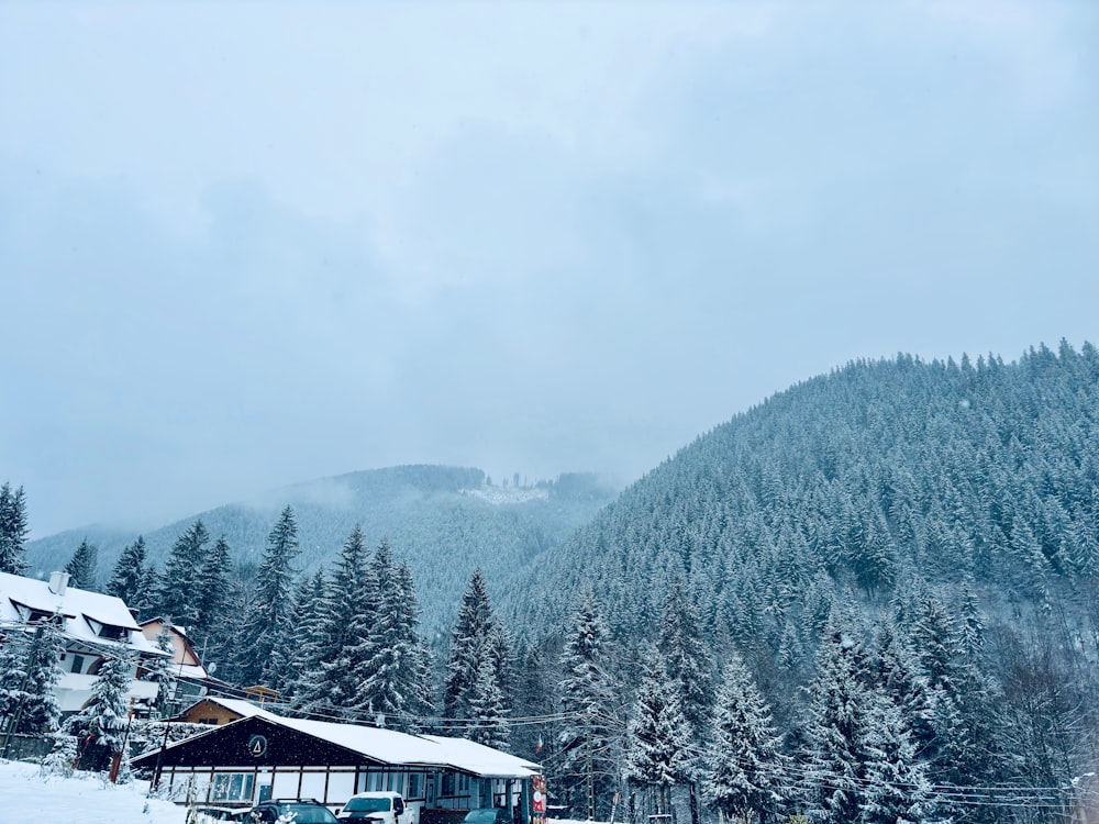 a snow covered mountain with a cabin in the foreground