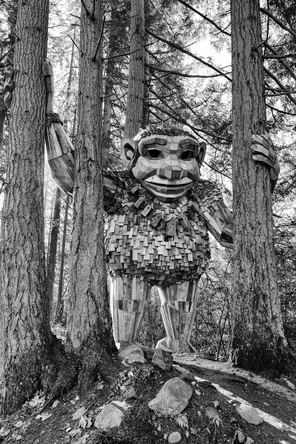 a statue of a creature in the middle of a forest