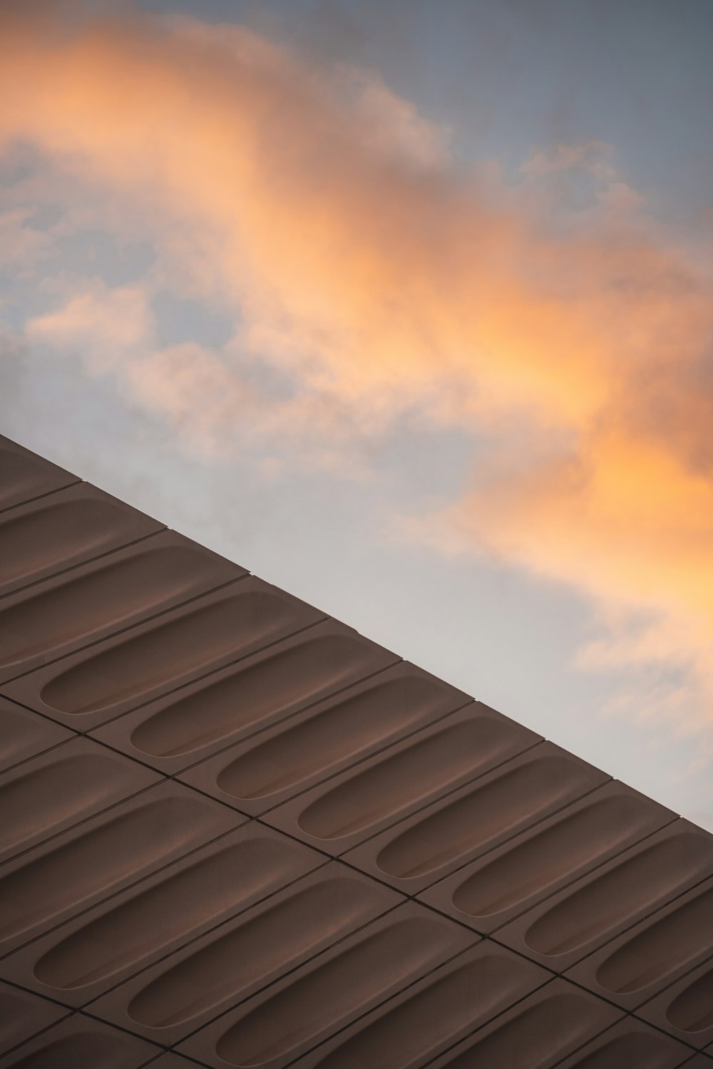 a plane flying in the sky over a building