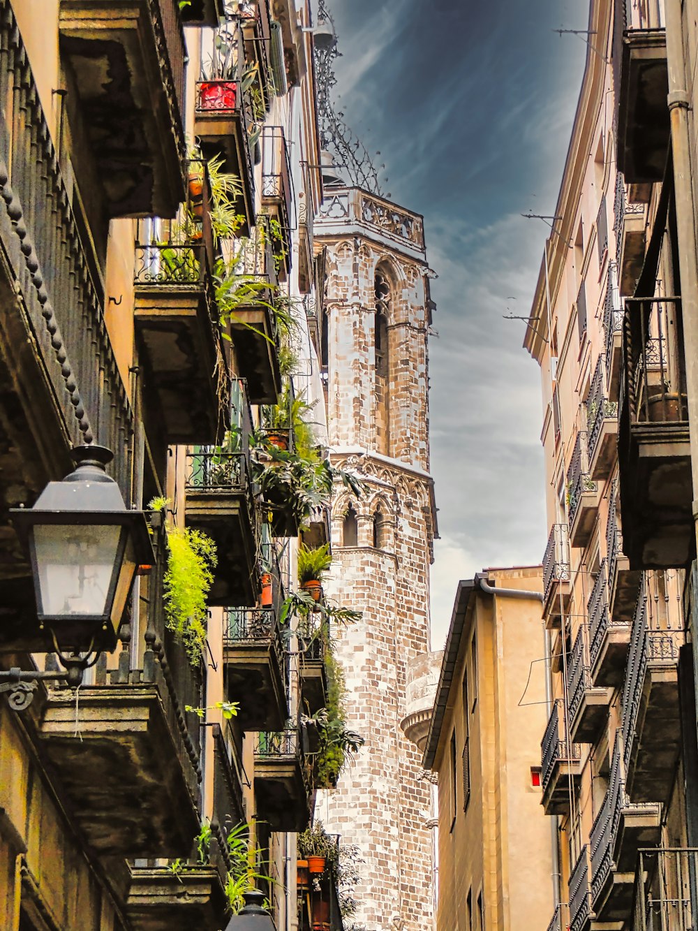 a narrow city street with tall buildings and a clock tower in the background