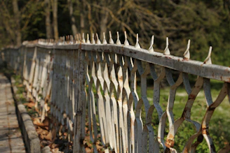 Before and after photos side by side: a rusty metal fence and the same fence cleaned by laser.
