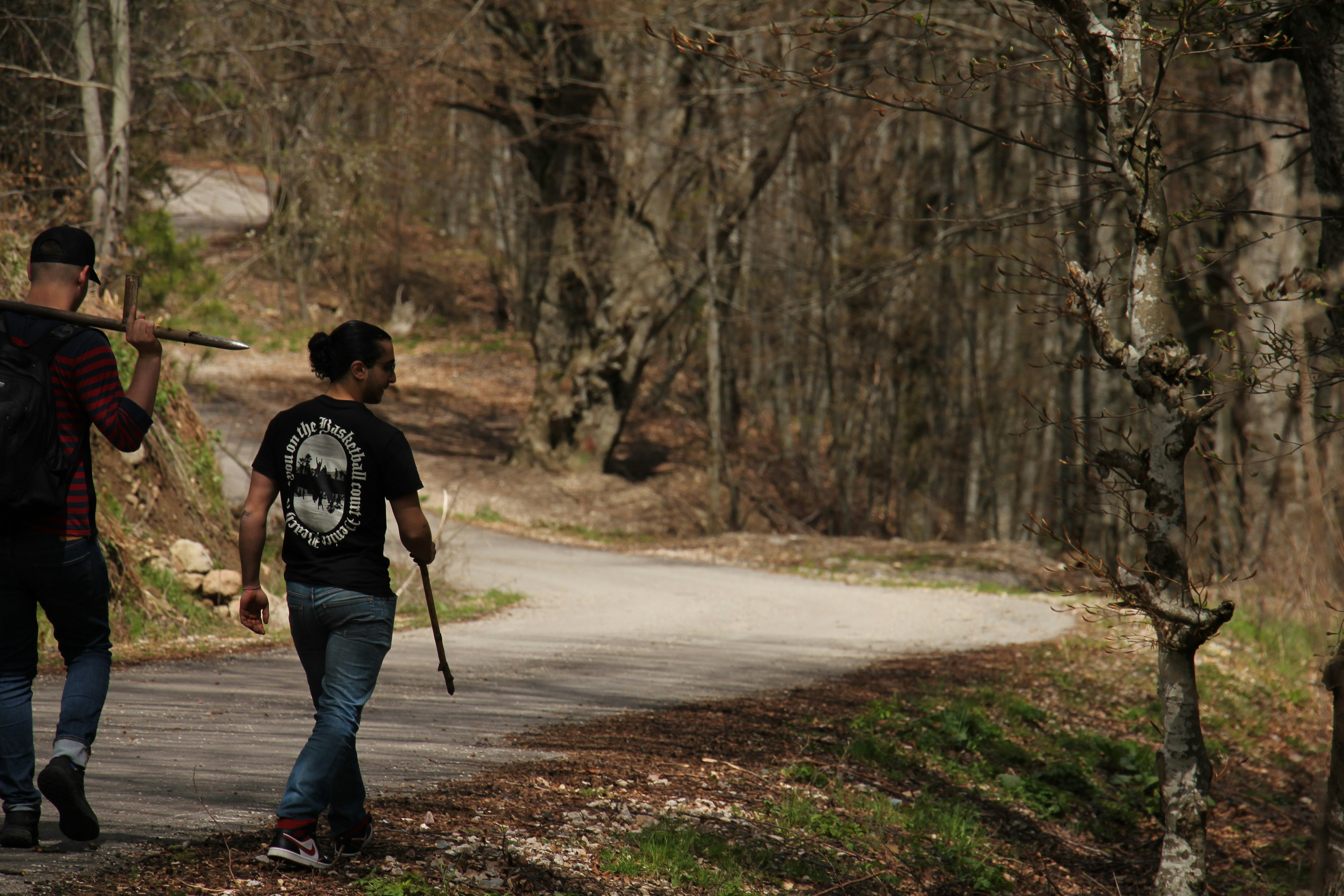 a couple of men walking down a dirt road