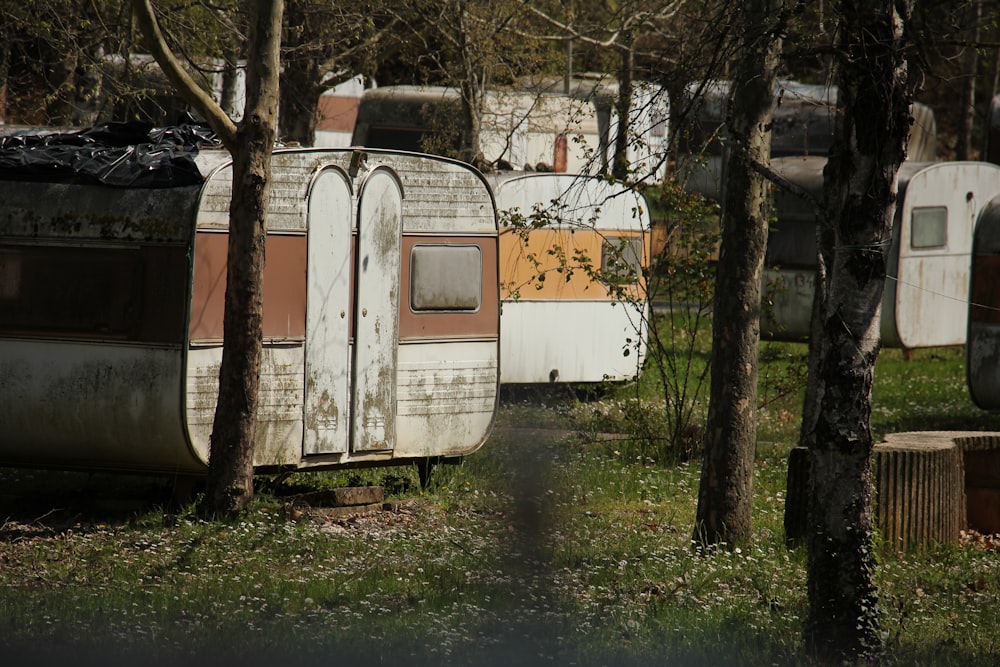 an old trailer is parked in a wooded area