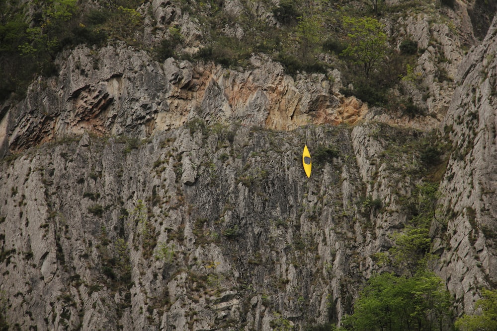 a yellow surfboard sticking out of the side of a mountain