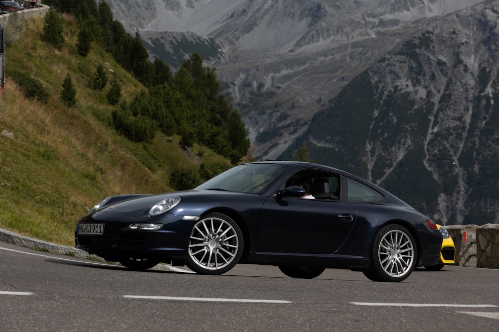 a black sports car parked on the side of a mountain road