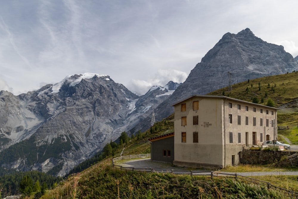 un edificio en la ladera de una colina con montañas al fondo