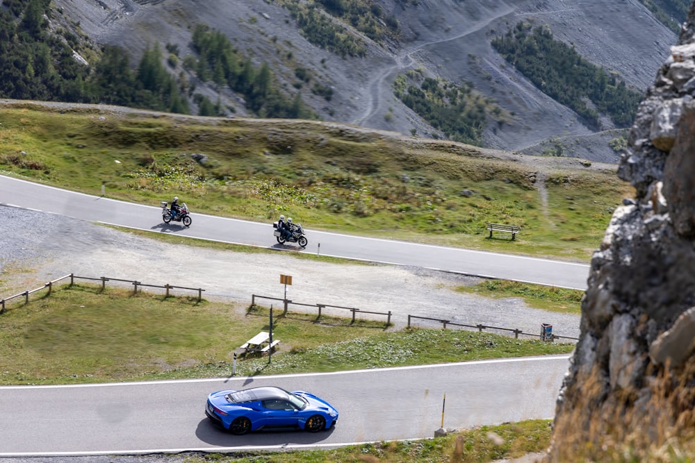 Ein blauer Sportwagen, der eine kurvenreiche Straße entlangfährt