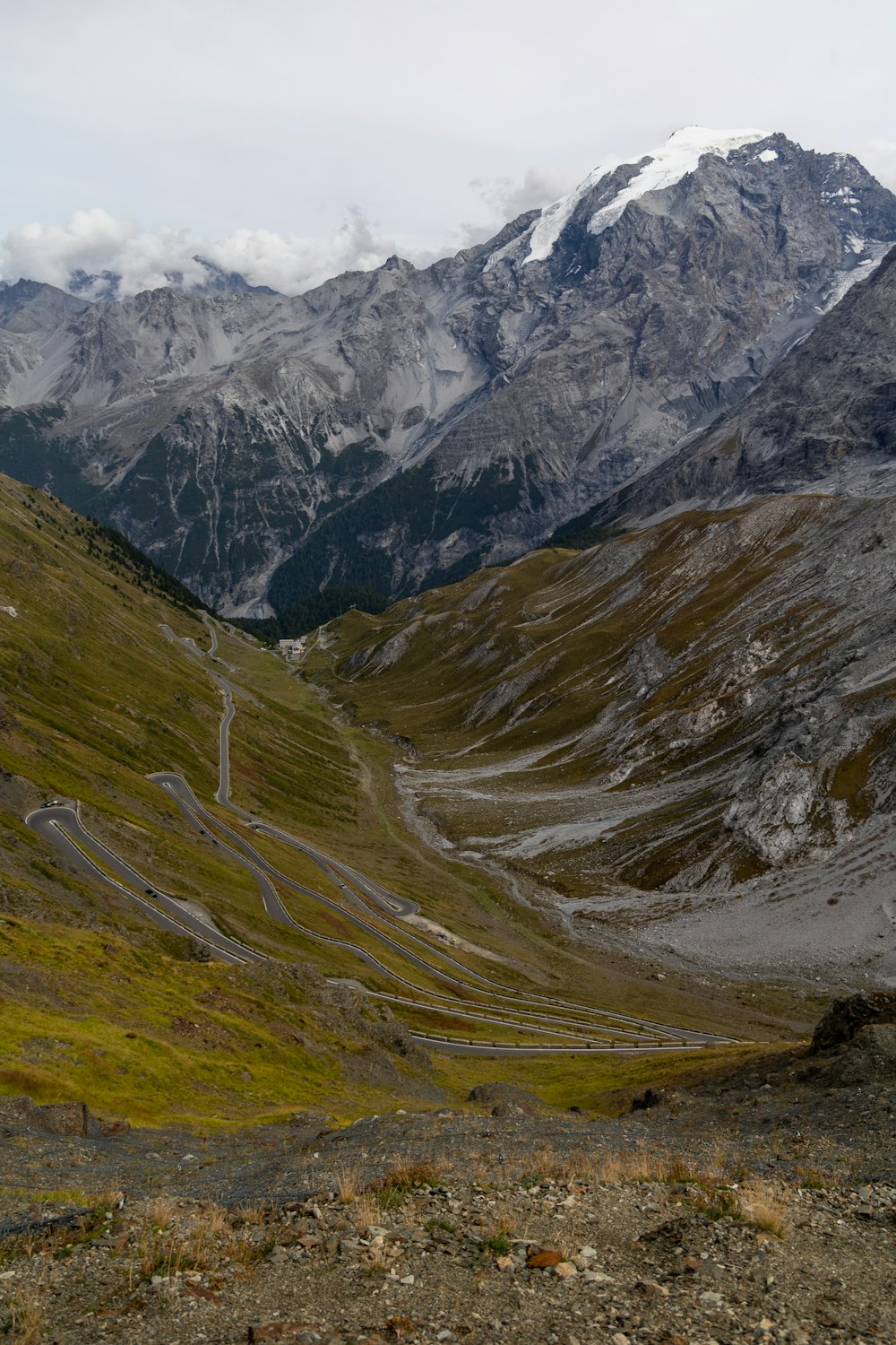 a mountain range with a winding road in the foreground