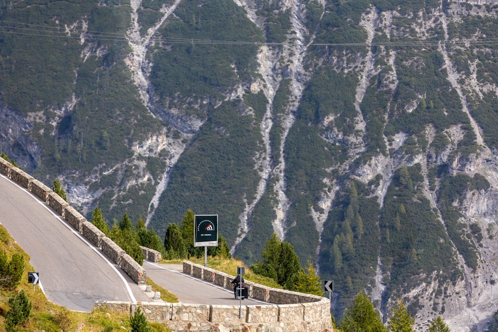 a motorcycle is driving down a mountain road