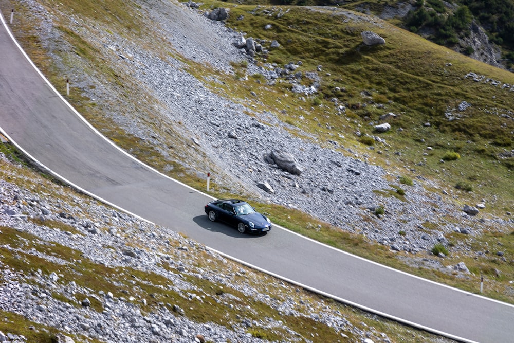 Un coche conduciendo por una sinuosa carretera de montaña