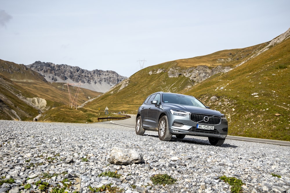 a car driving on a gravel road in the mountains