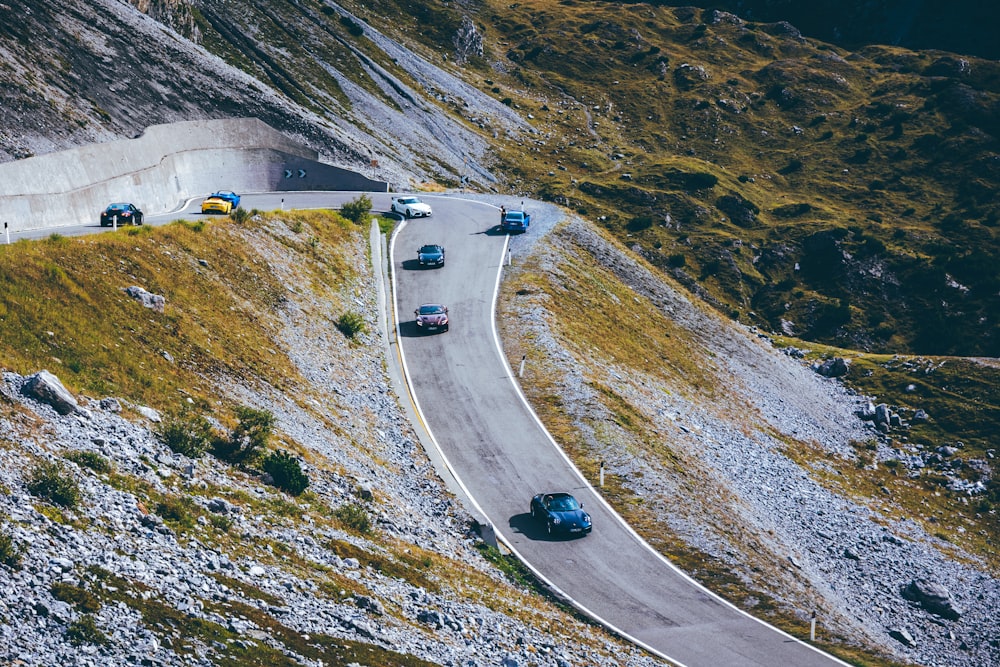 a group of cars driving down a mountain road