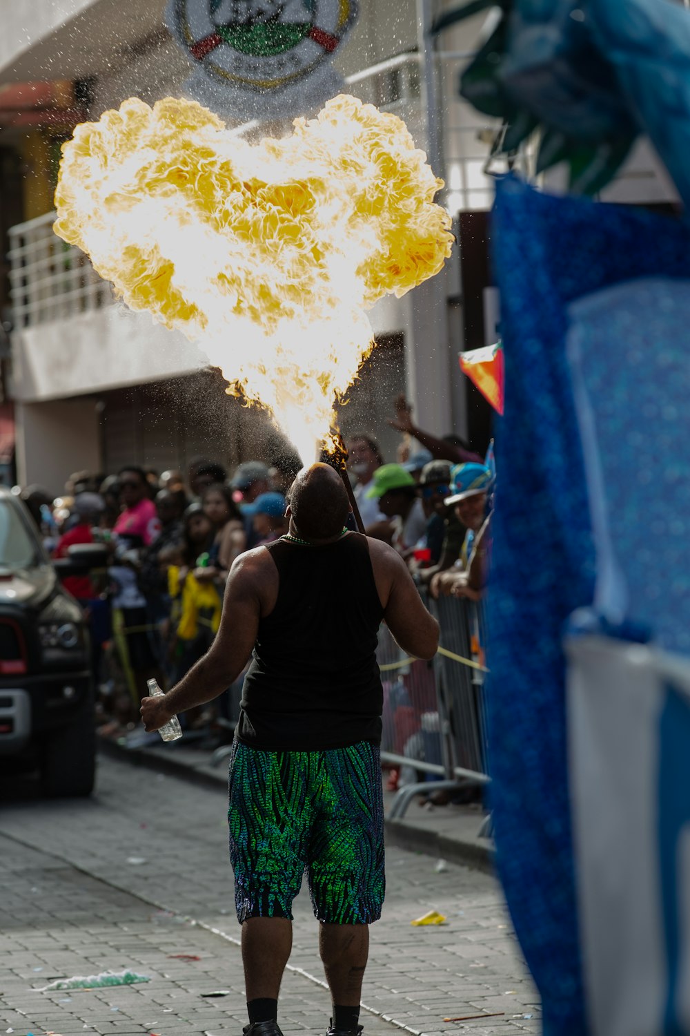 a man standing on a street holding a yellow object in front of a crowd