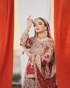 A graceful anarkali suit in deep gold tones, featuring fine threadwork and flowing fabric, styled with traditional jewelry.