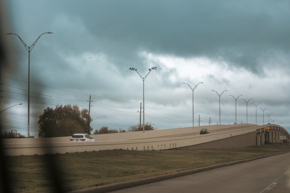 a car driving down a highway under a cloudy sky