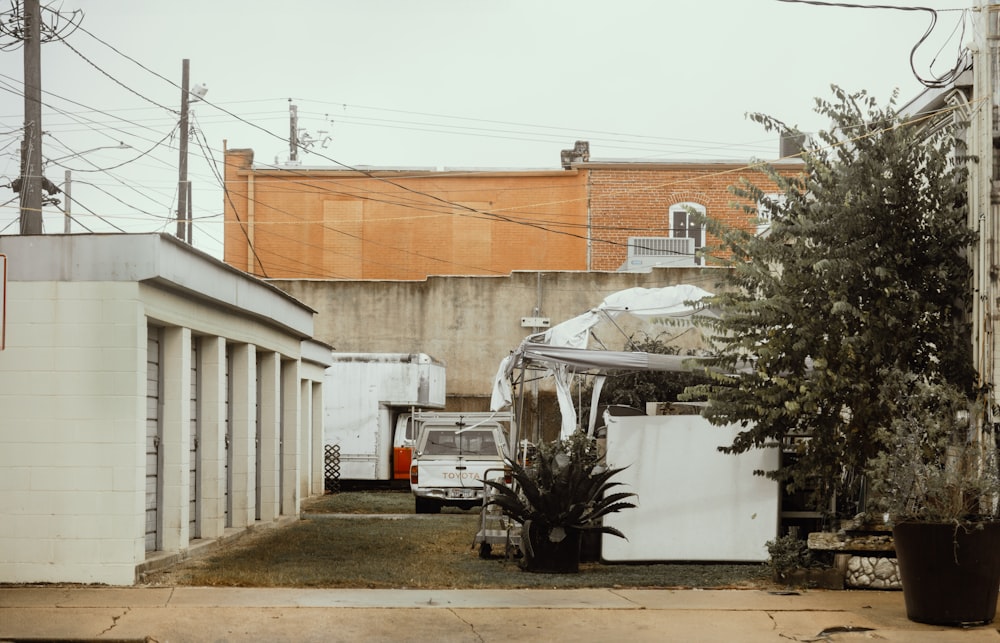 a white refrigerator sitting in a yard next to a tree