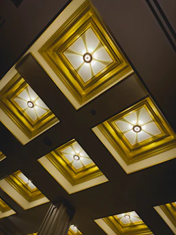 Close-up of a craftsman installing elegant gypsum board ceiling with recessed lighting