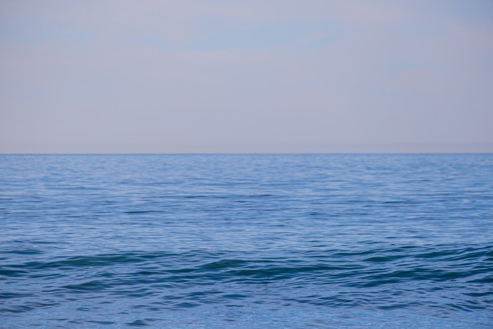 a large body of water sitting under a blue sky