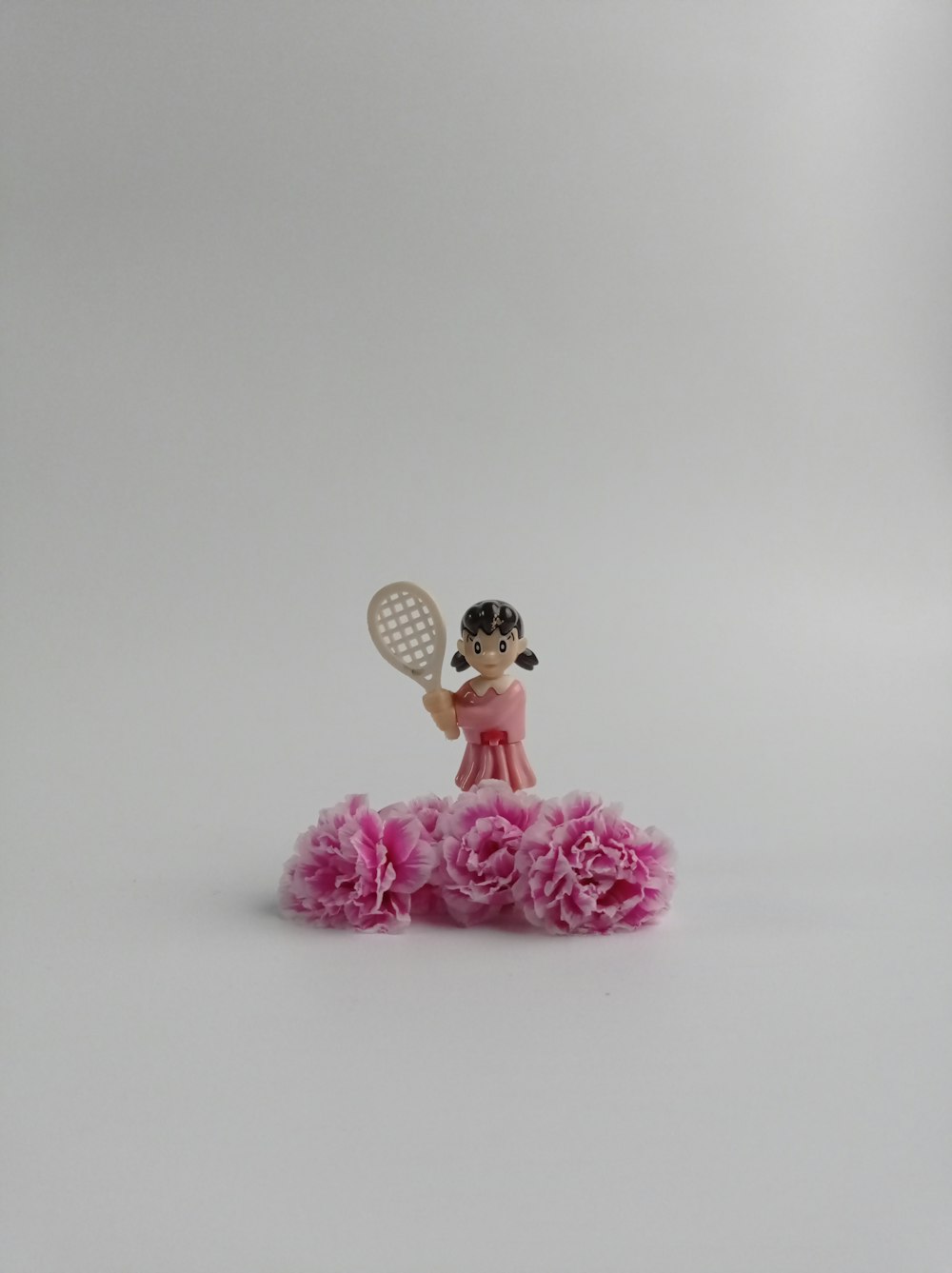 a figurine of a girl holding a tennis racquet