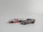 Two toy cars are positioned on a plain background. One is designed in a sleek silver color with golden rims, while the other is a convertible styled in white with red and blue accents.