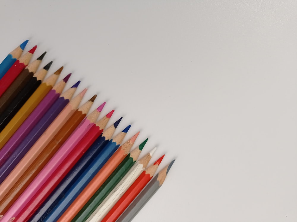 a group of colored pencils lined up in a row