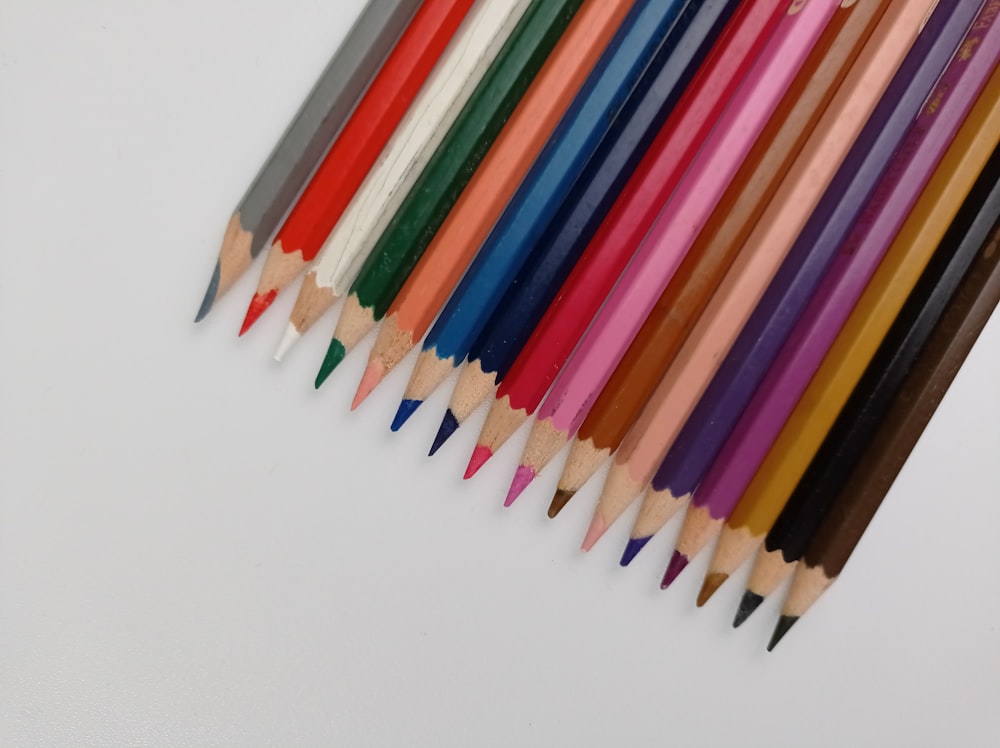 a group of colored pencils lined up in a row