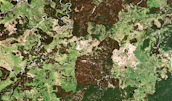 Satellite view of lush green landscapes and urban areas highlighting resource management.