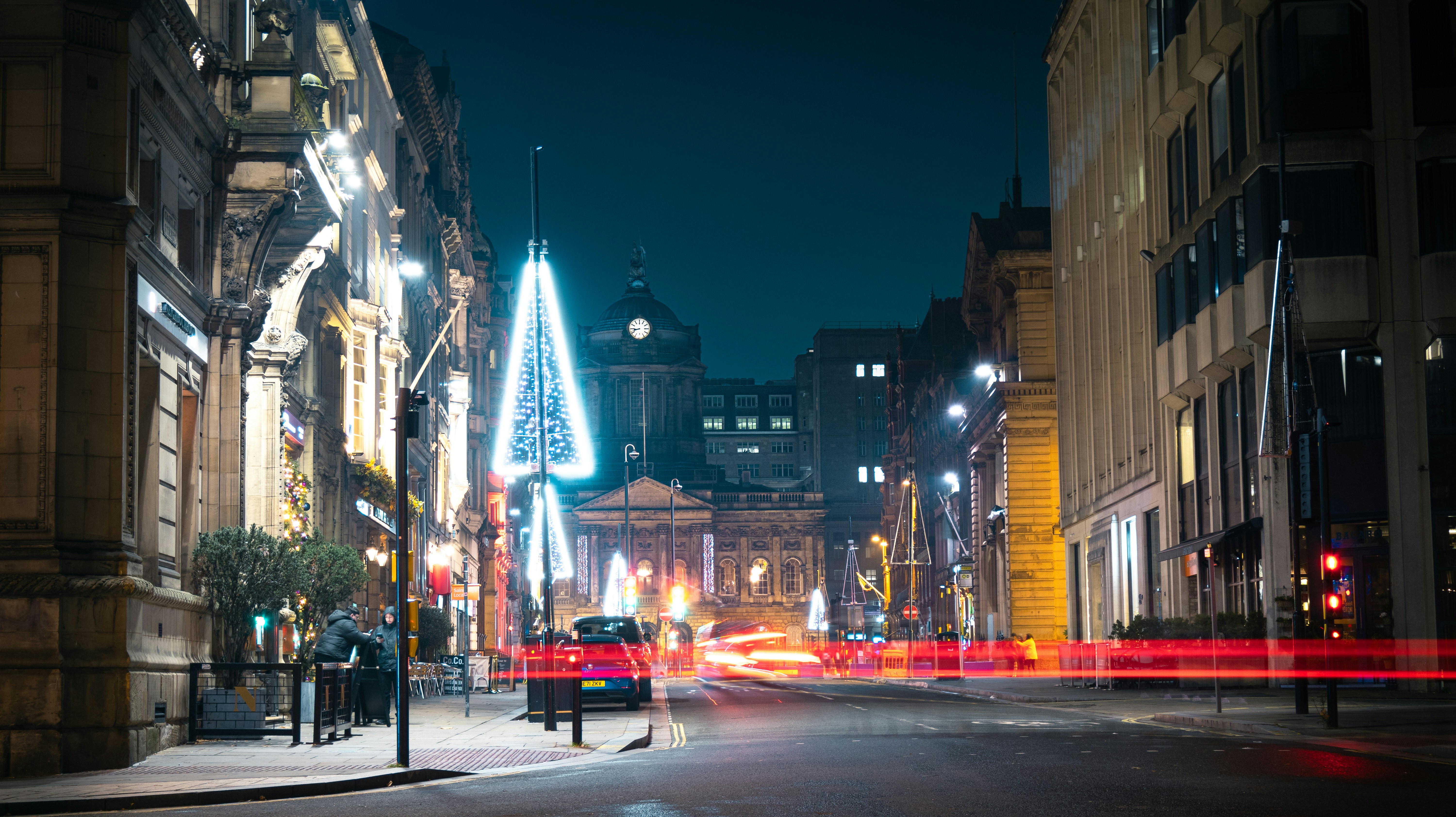 a city street at night with a clock tower in the background