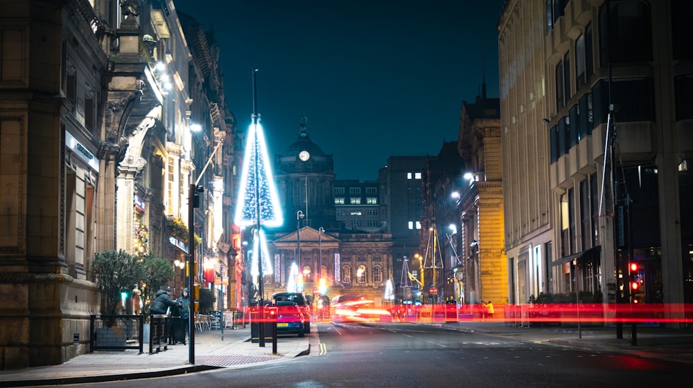 a city street at night with a clock tower in the background