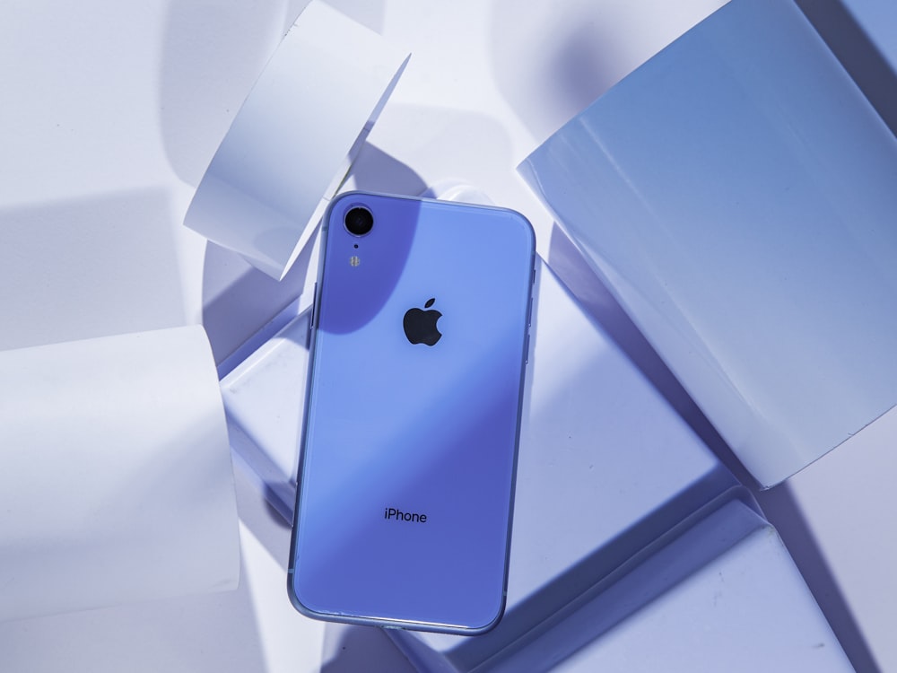 a blue iphone sitting on top of a white table