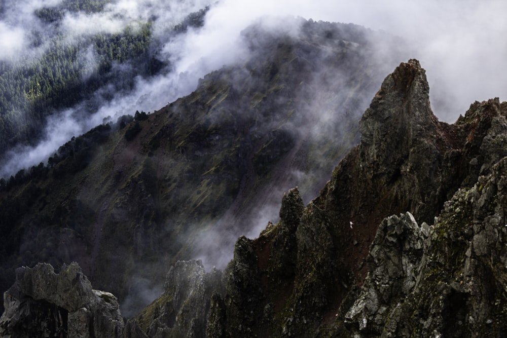 a mountain covered in fog and clouds on a cloudy day