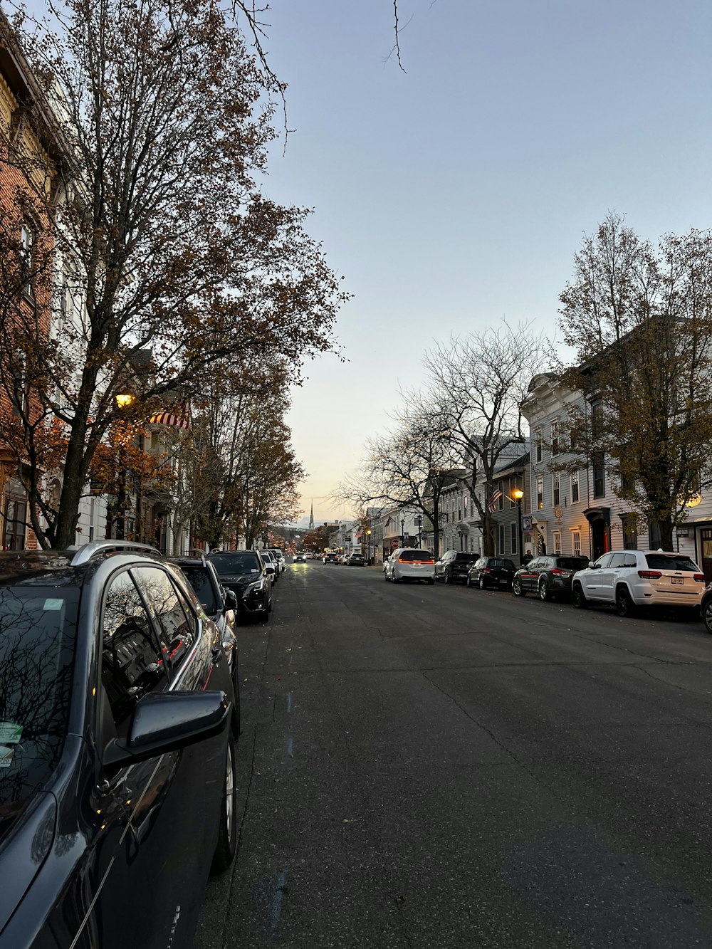 a street lined with parked cars next to tall buildings