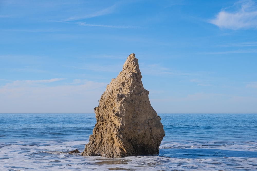 ein großer Felsen, der aus dem Meer ragt