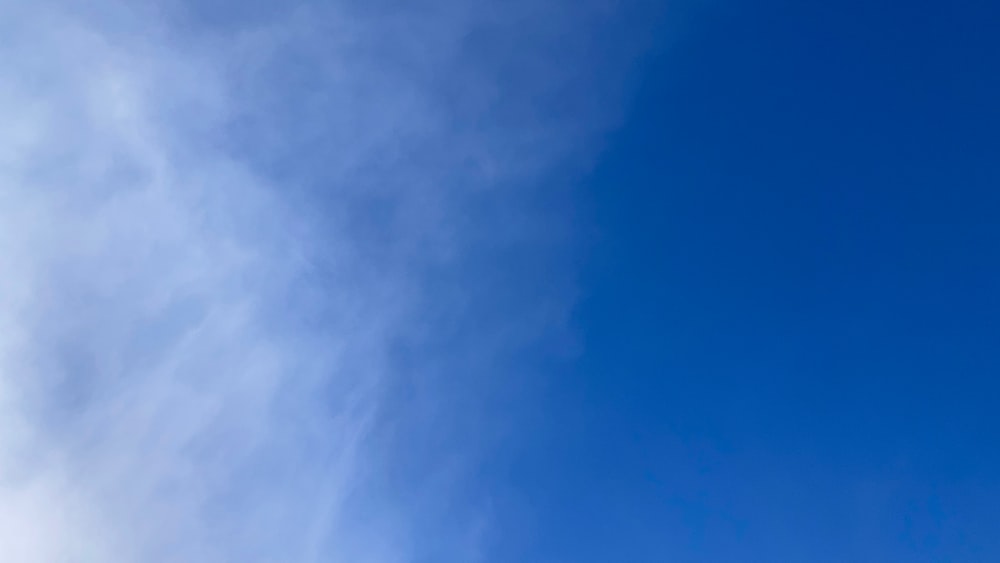 a person flying a kite in a blue sky